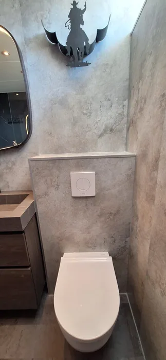 Wit hangtoilet voor voorzetwand met wandpanelen in steenlook en witte bedieningsplaat