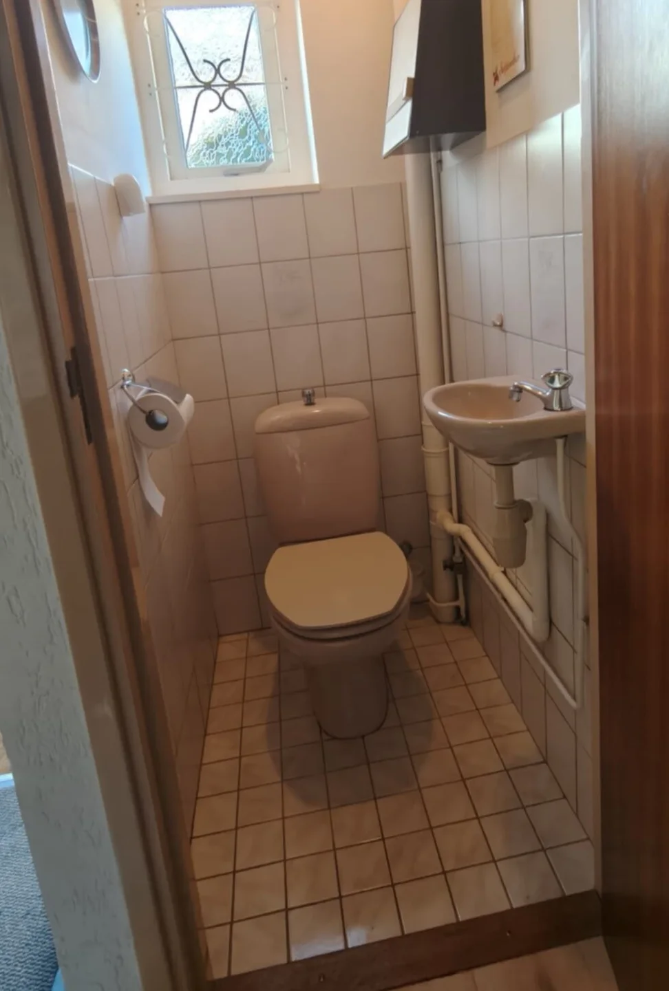 Toilet: situatie vóór het werk — Staand toilet met fonteintje en witte tegels wordt een hangtoilet met voorzetwand en betonlook wandpanelen.